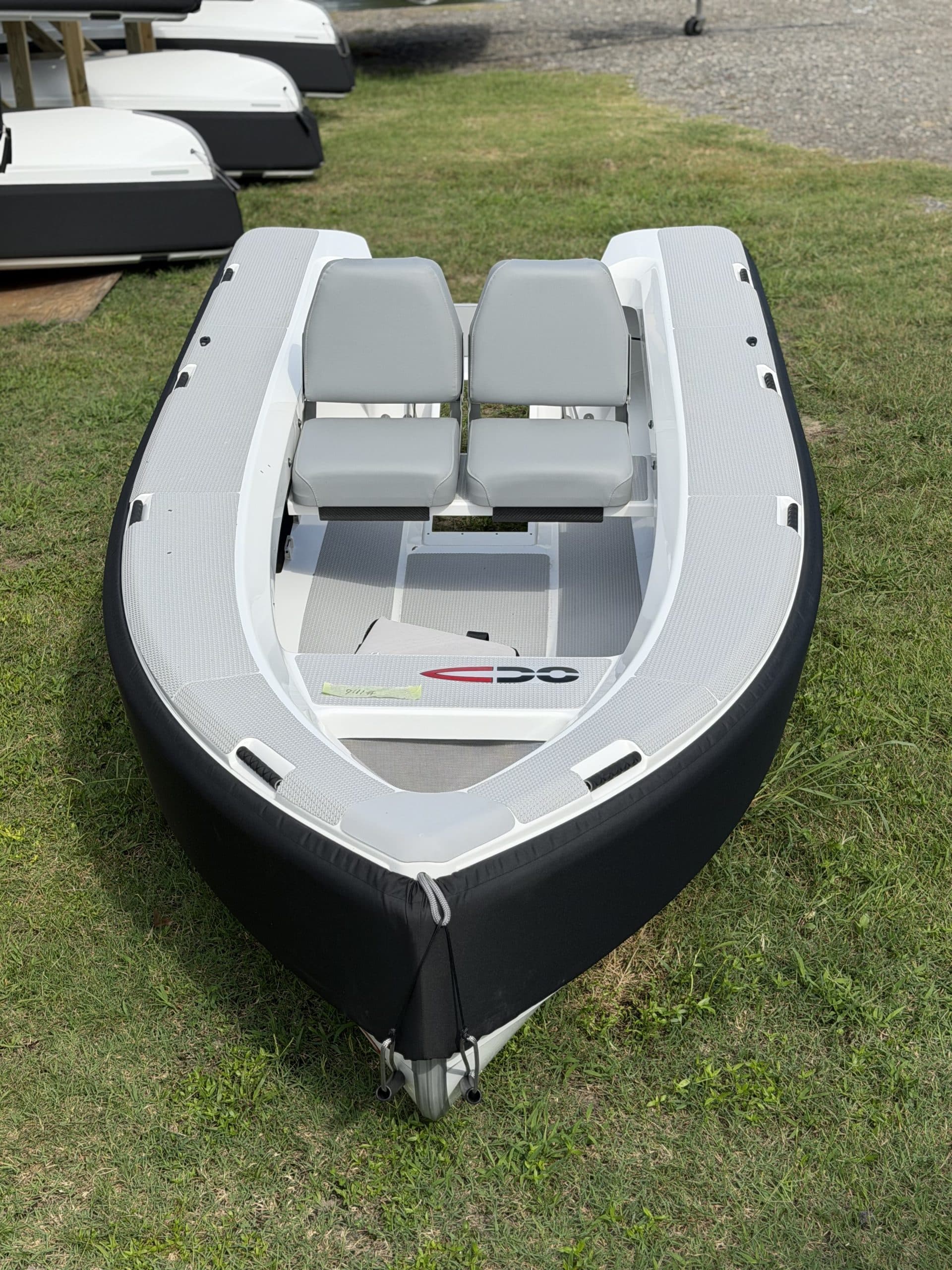 Overhead view of a small rigid inflatable tender, showing the bow, open cockpit, two forward-facing seats, and textured gray deck on a 2026 Offshore Cruising Tenders OC300