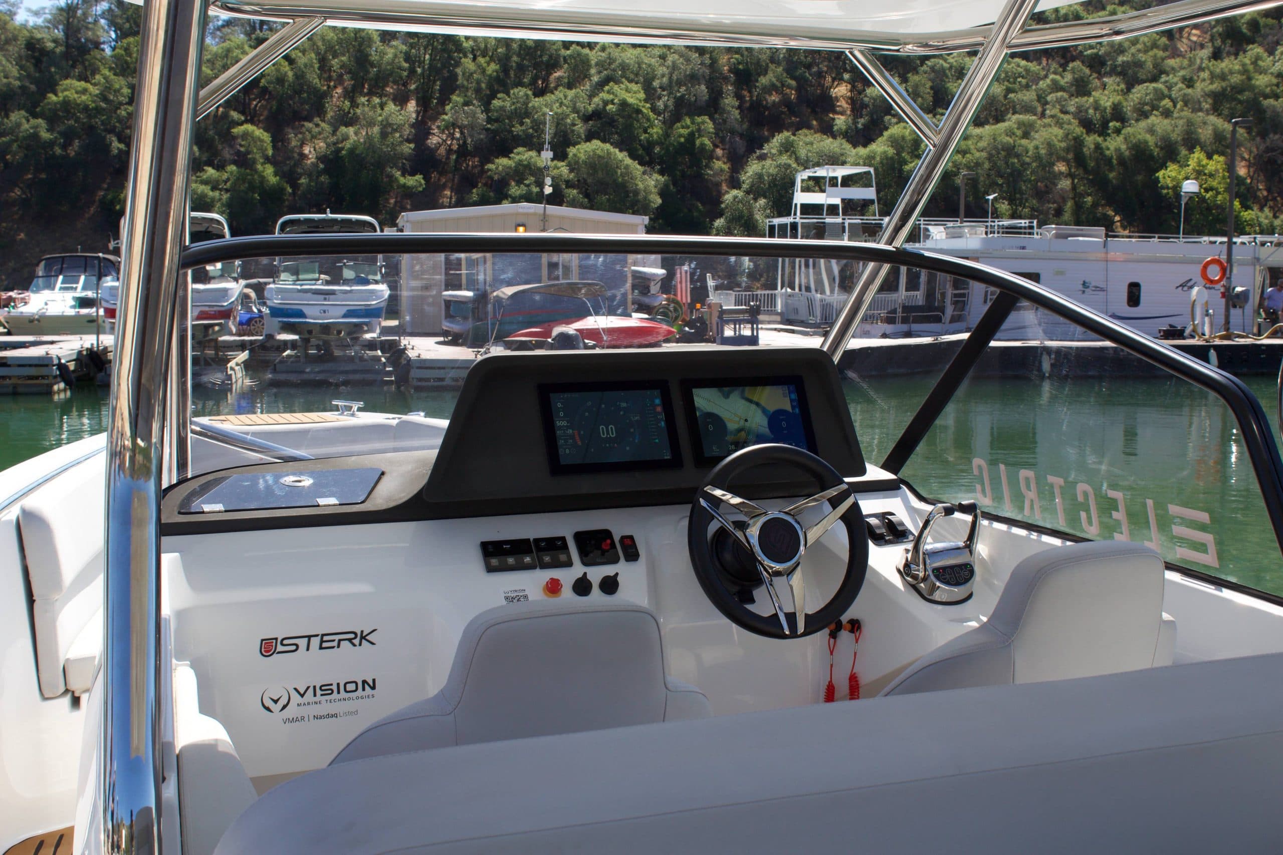 Sterk 31E helm and forward cockpit viewed from aft, with steering wheel and instrument displays visible.
