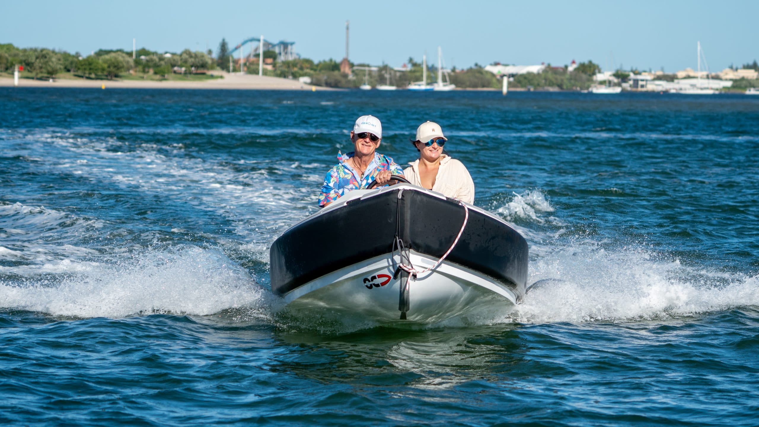 Two people in a white tender (2026 Offshore Cruising Tenders OC400) with black rub rail heading towards the camera.