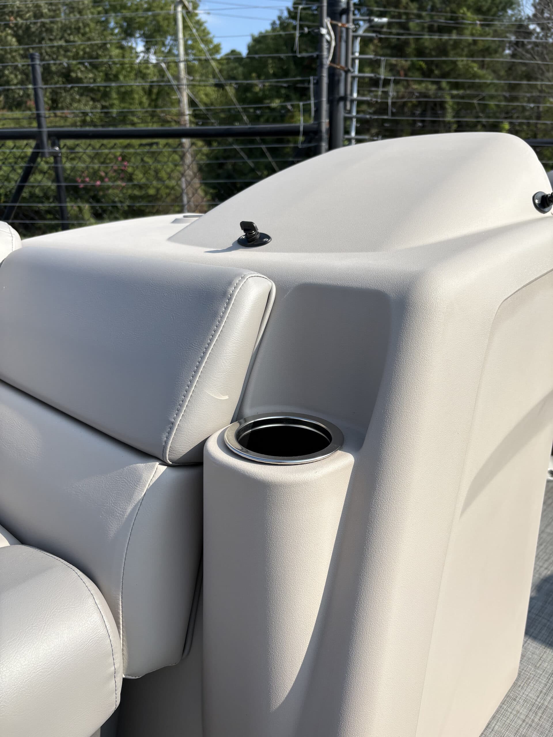 Close-up of a boat’s (2026 Princecraft Jazz 19 4s) upholstered interior, showing a cup holder and contoured seat back from the side.