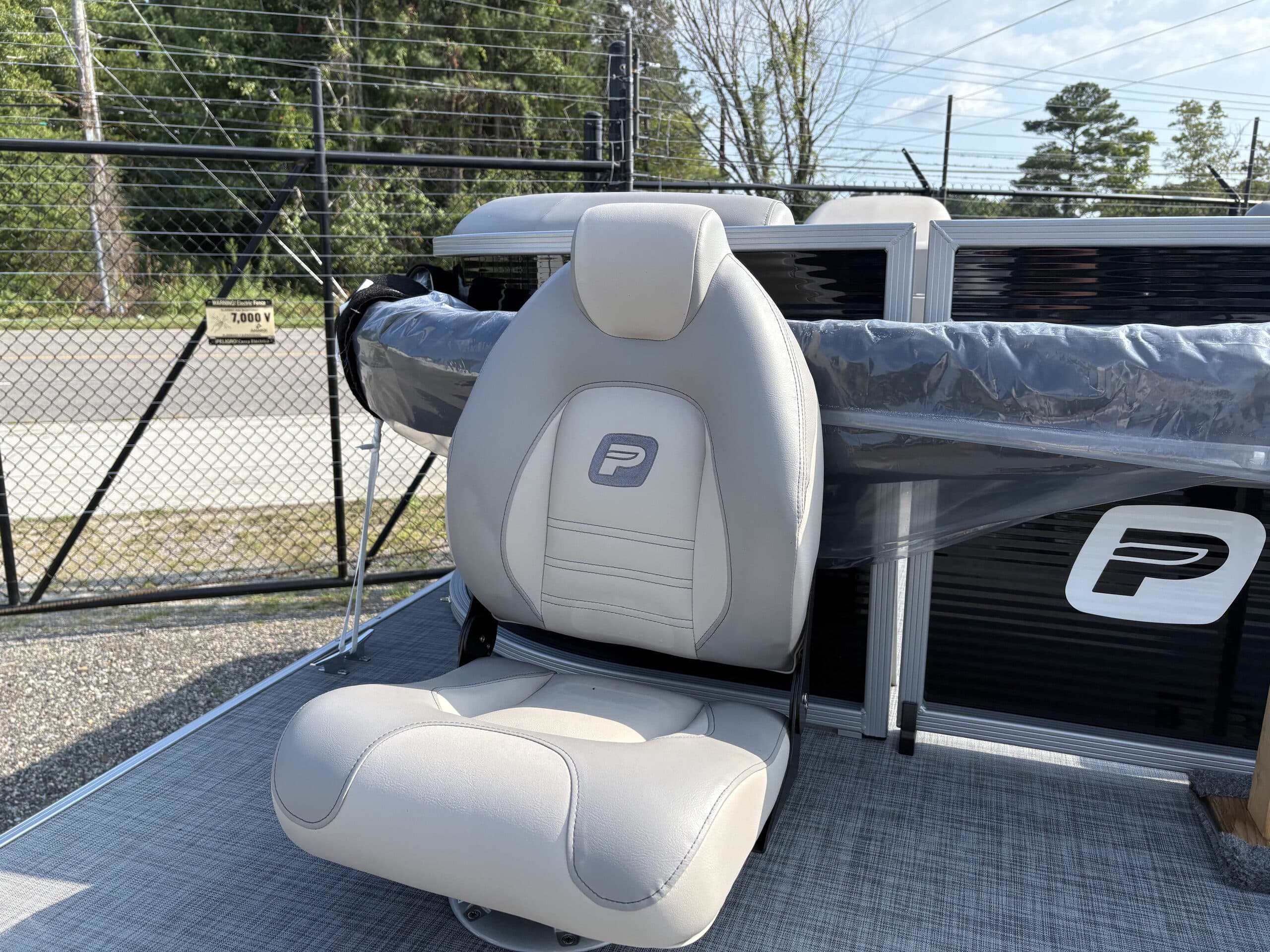 Close-up of a padded helm seat and side panel with Princecraft branding on a pontoon boat (2026 Princecraft Jazz 19 4s) deck.