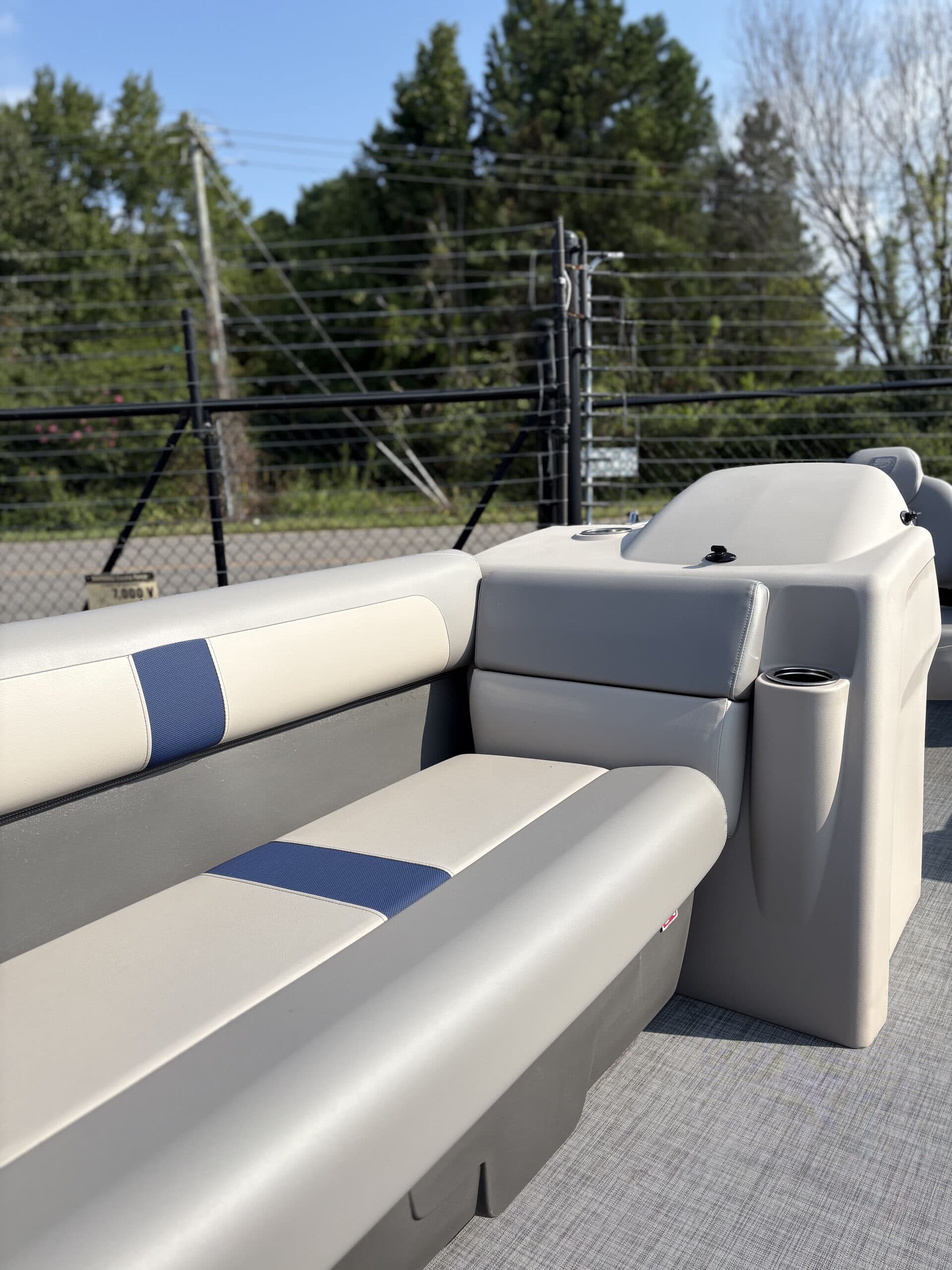 Close view from inside a 2026 Princecraft Jazz 19 4s of the rear bench seat, side seating, and upholstered corner backrest with blue accent
