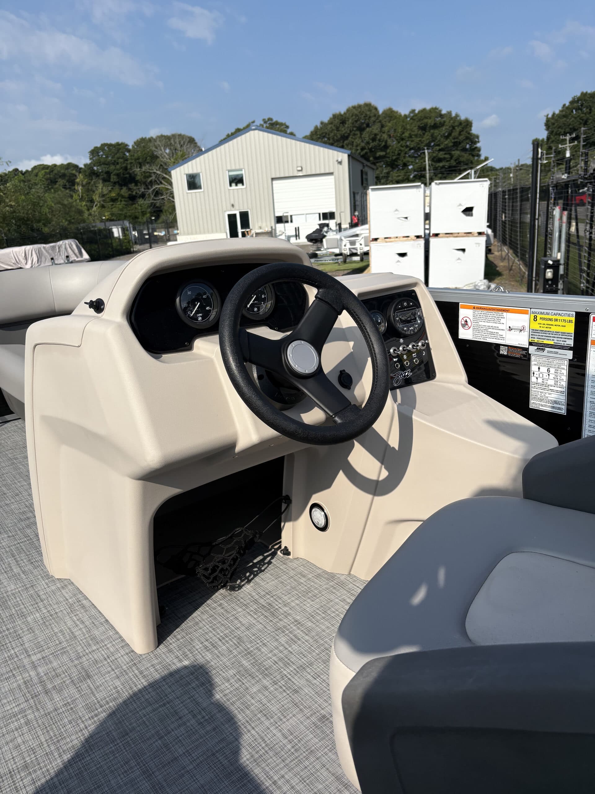 View from the helm showing the steering wheel, dashboard gauges, controls, windshield, and captain seat is visible (2026 Princecraft Jazz 19 4s)