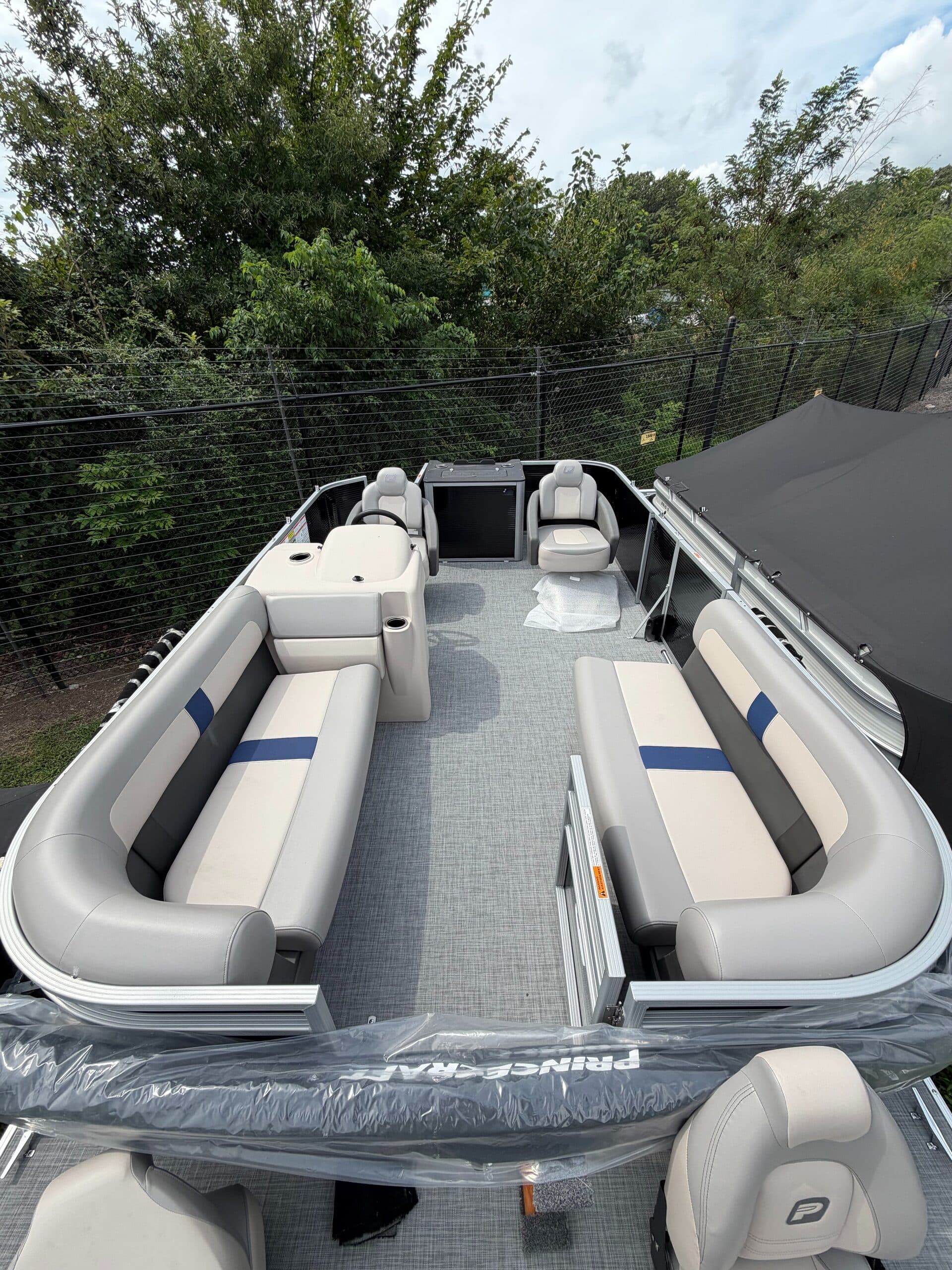 Rear-facing view into a covered Princecraft Jazz 19 4s pontoon boat cockpit with wraparound seating and helm console