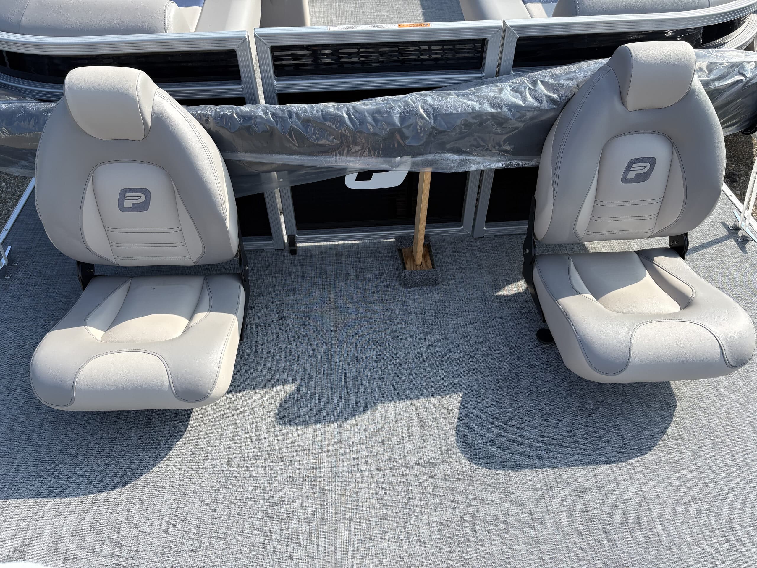 Two swivel seats and carpeted cockpit floor viewed from above, with Princecraft logo engraved on seat cushion (2026 Princecraft Jazz 19 4s)