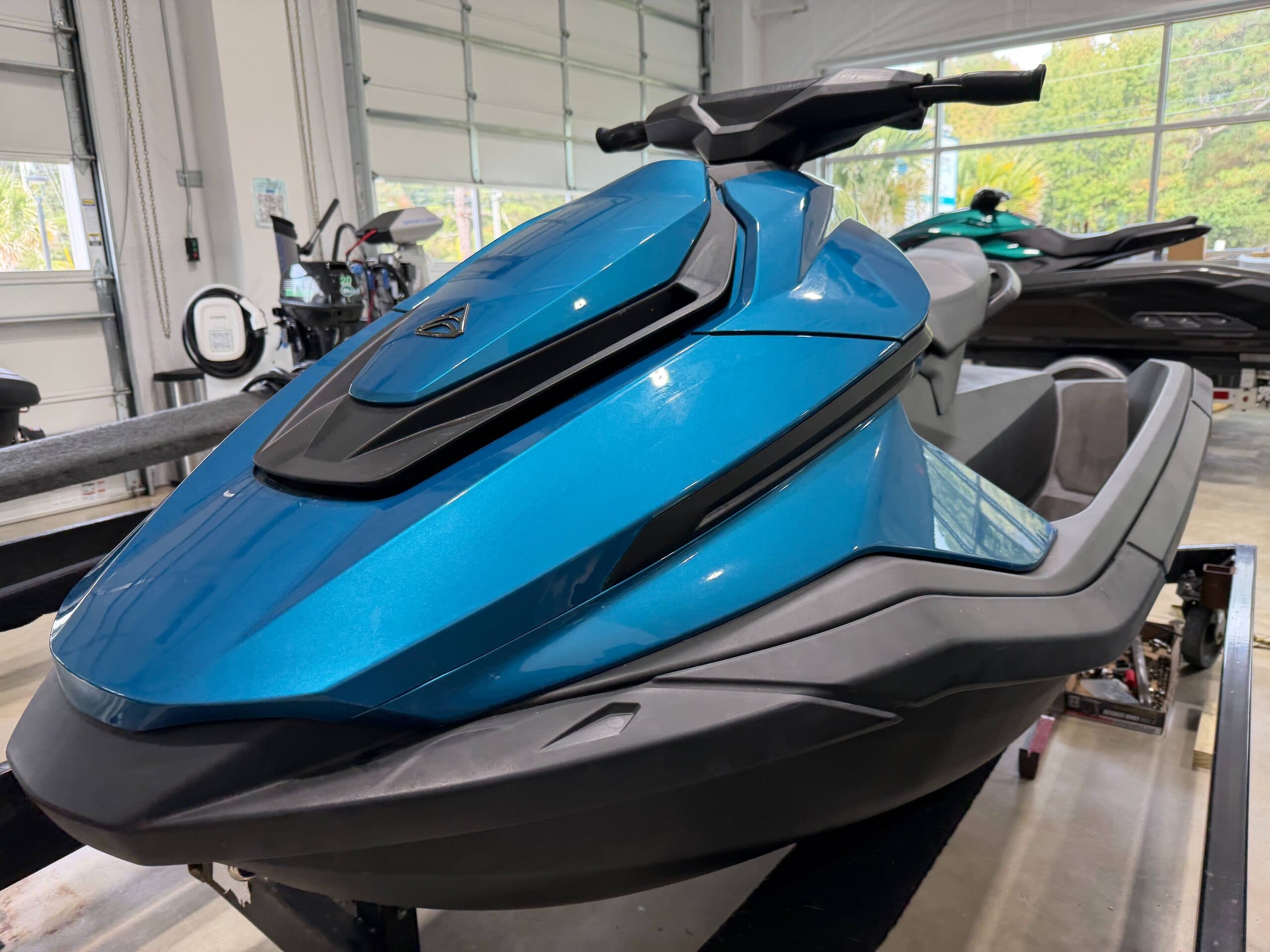 Blue personal watercraft (Taiga Orca P2) on a showroom stand, viewed from the front-left side.