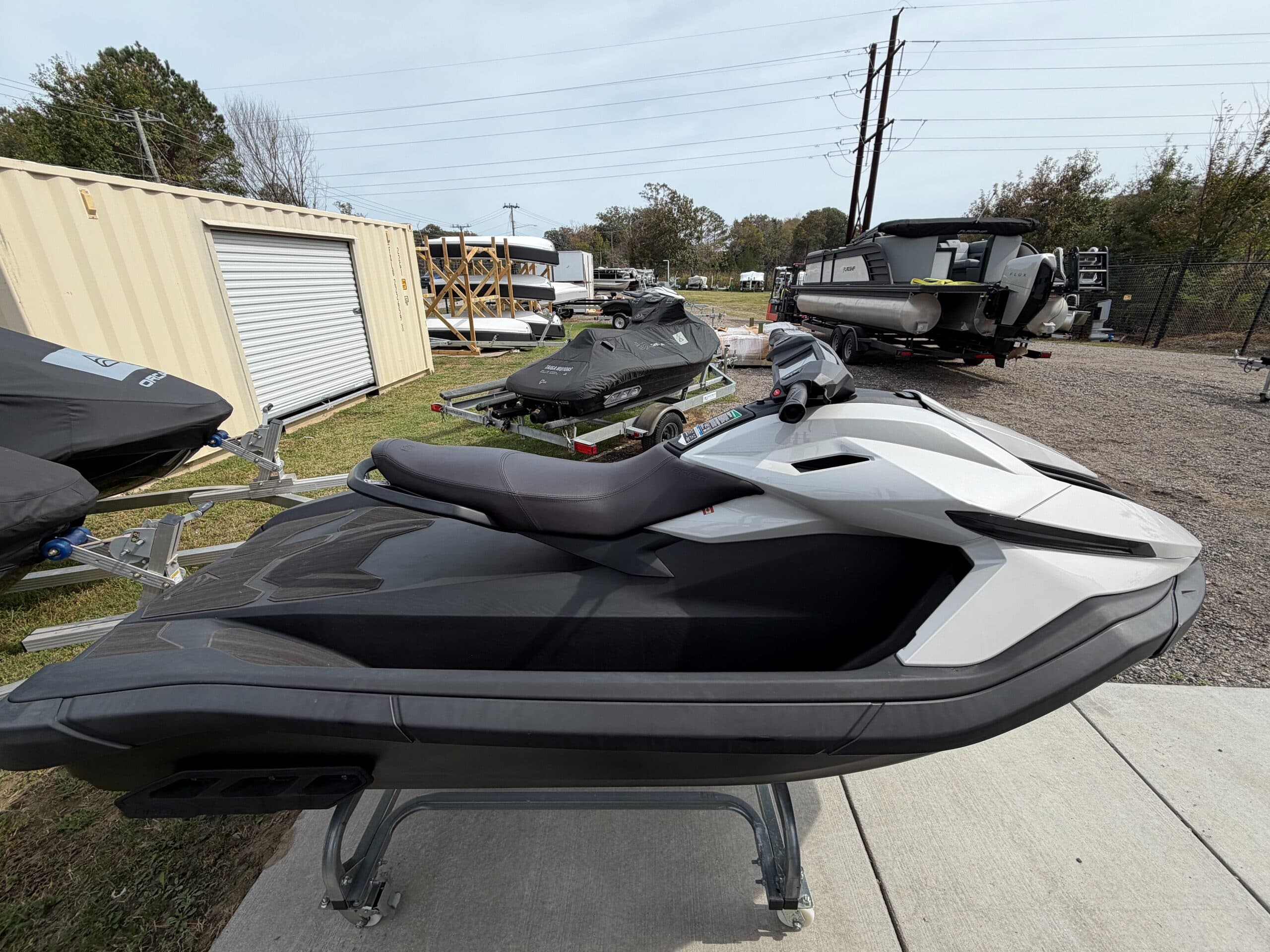 White and black personal watercraft on a stand, viewed from the side with the bow to the right.
