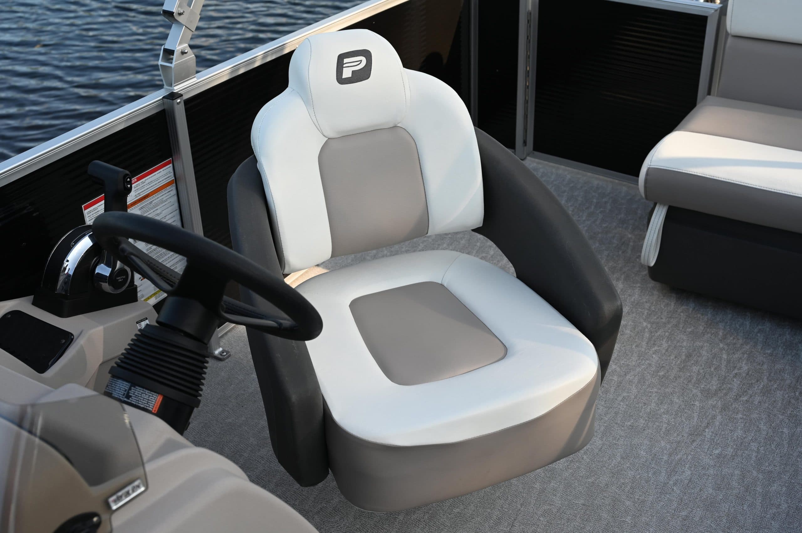 Close view of the helm and captain’s chair in a Princecraft Vectra 19 L pontoon boat, viewed from the cockpit.