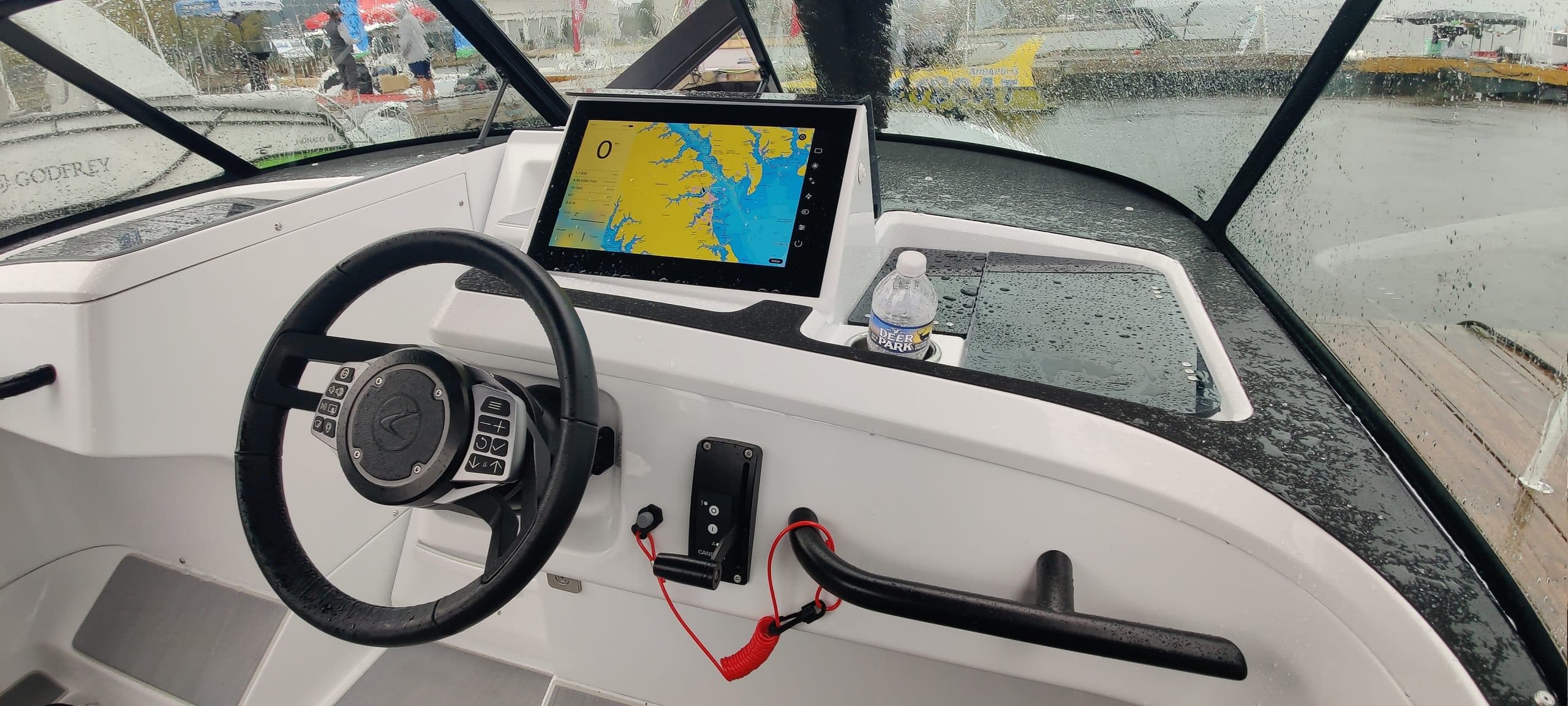 Helm of the Candela C-8 viewed from the cockpit, with steering wheel and navigation display visible.
