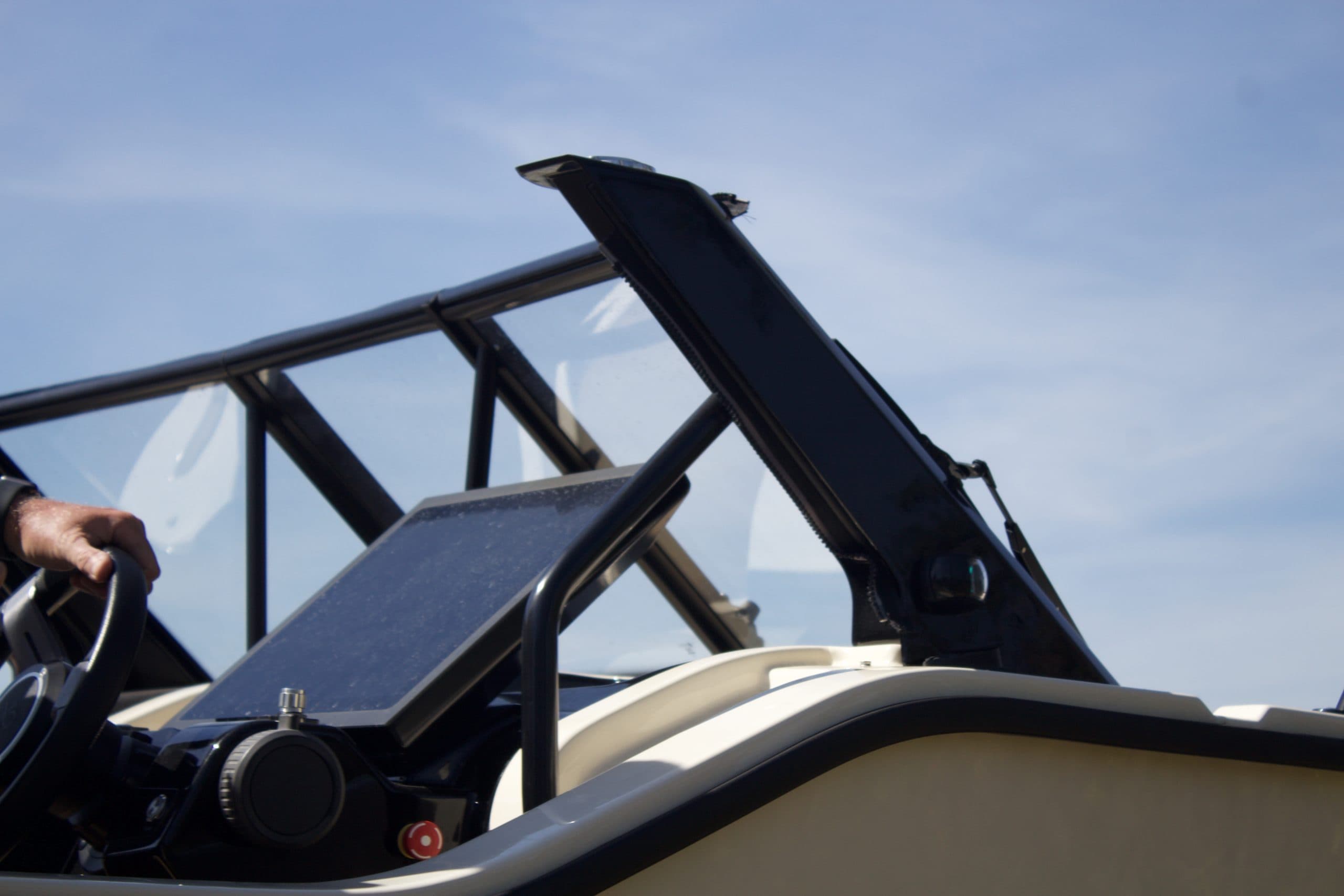 X Shore XS1 helm and windscreen viewed from the side, with a partial view of the steering wheel and dashboard.
