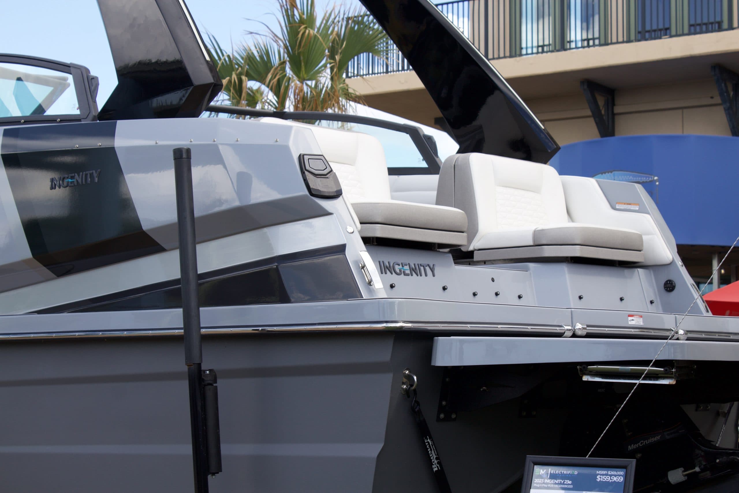Side view of an Ingenity 23E boat showing the aft cockpit, white seating, wakeboard tower, and hull.