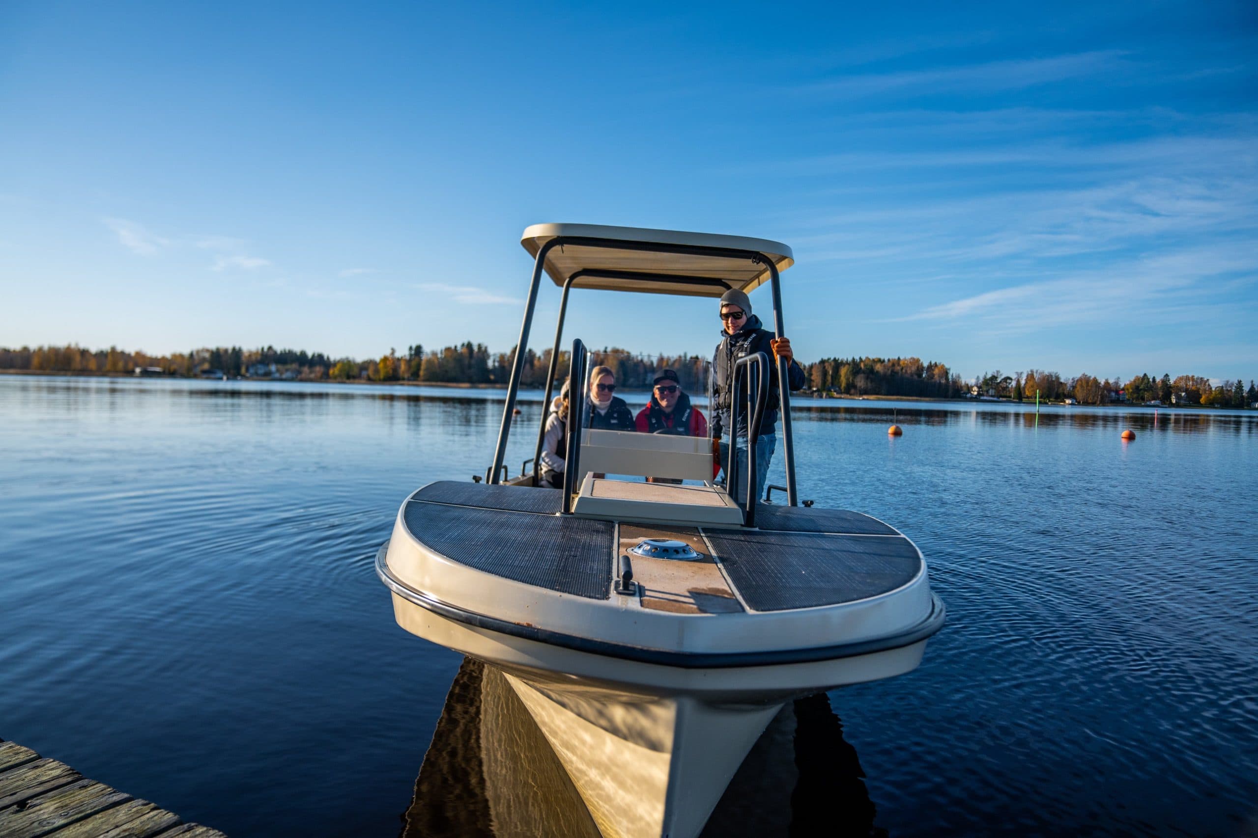 Elvene Amber viewed from the bow, with passengers aboard at a lakeside dock.