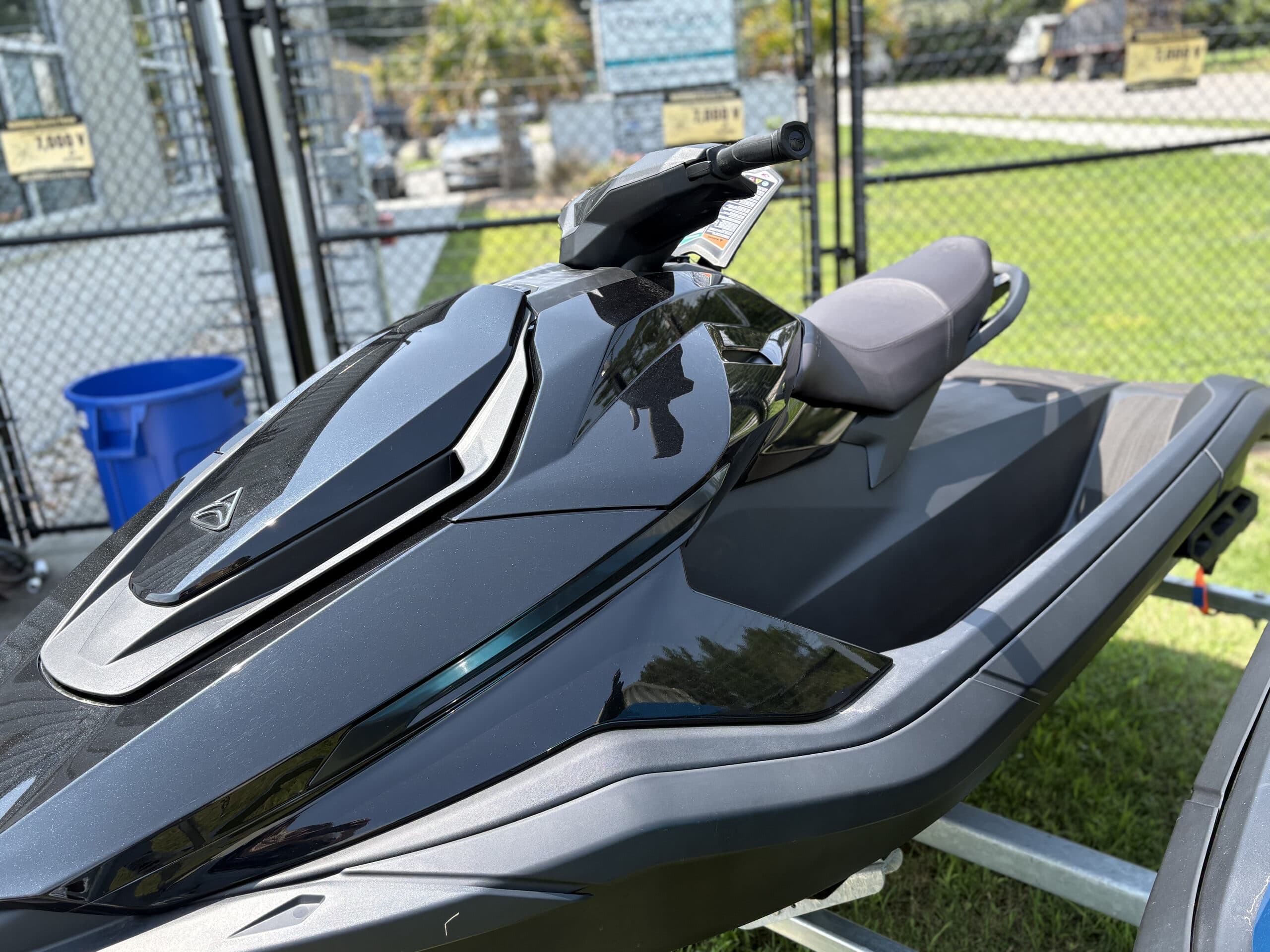 Close-up side view of a black personal watercraft (2026 Taiga Orca P2), showing the front bodywork, handlebars, seat, and rear deck.