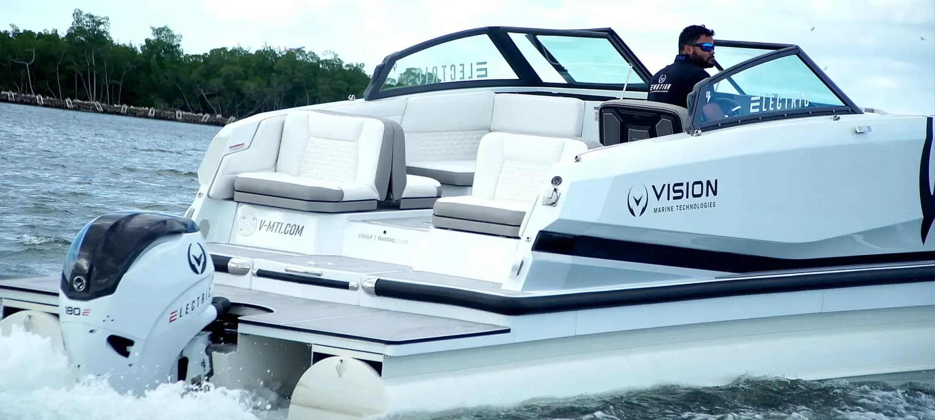 Side view of a white Vision Marine SPECTR boat underway, showing the stern, cockpit, outboard motor, and wake.