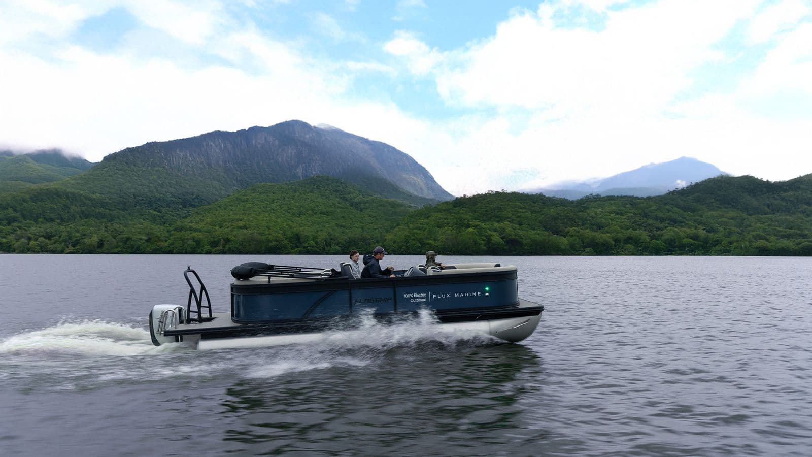 Electric boat cruising across a mountain lake, with forested mountains in the background.