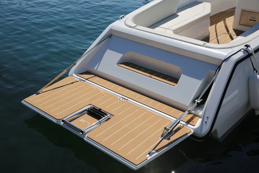 View from above the stern of a boat showing the open swim platform, rear seating, and teak-style decking.