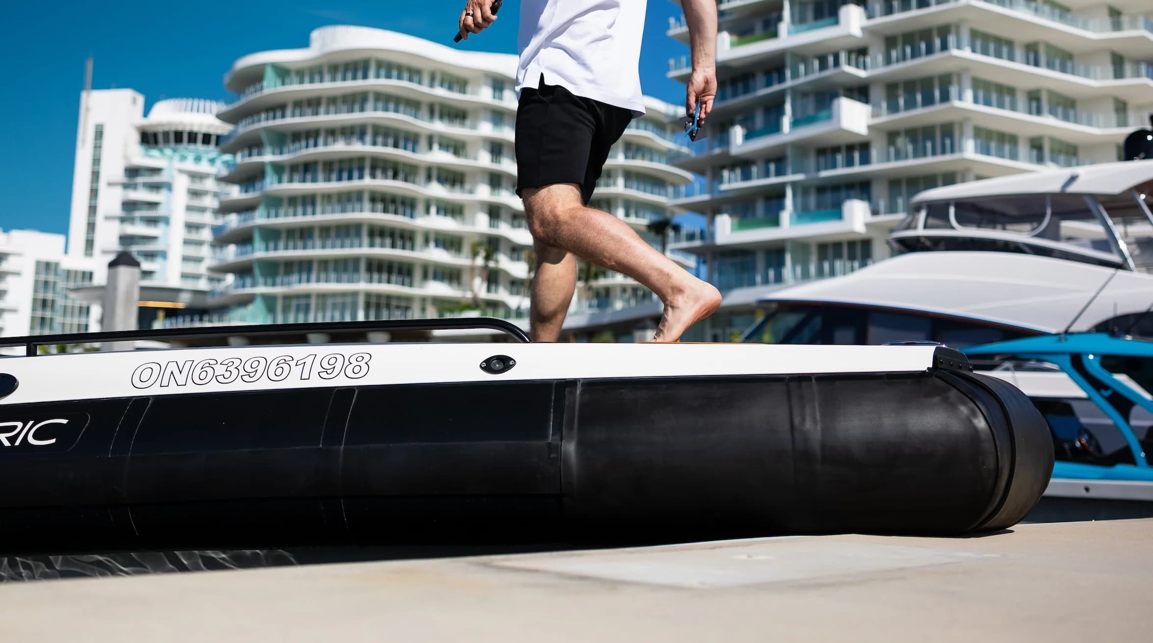 Close-up of the Voltari 260 T/T hull side and black inflatable tube at a waterfront marina