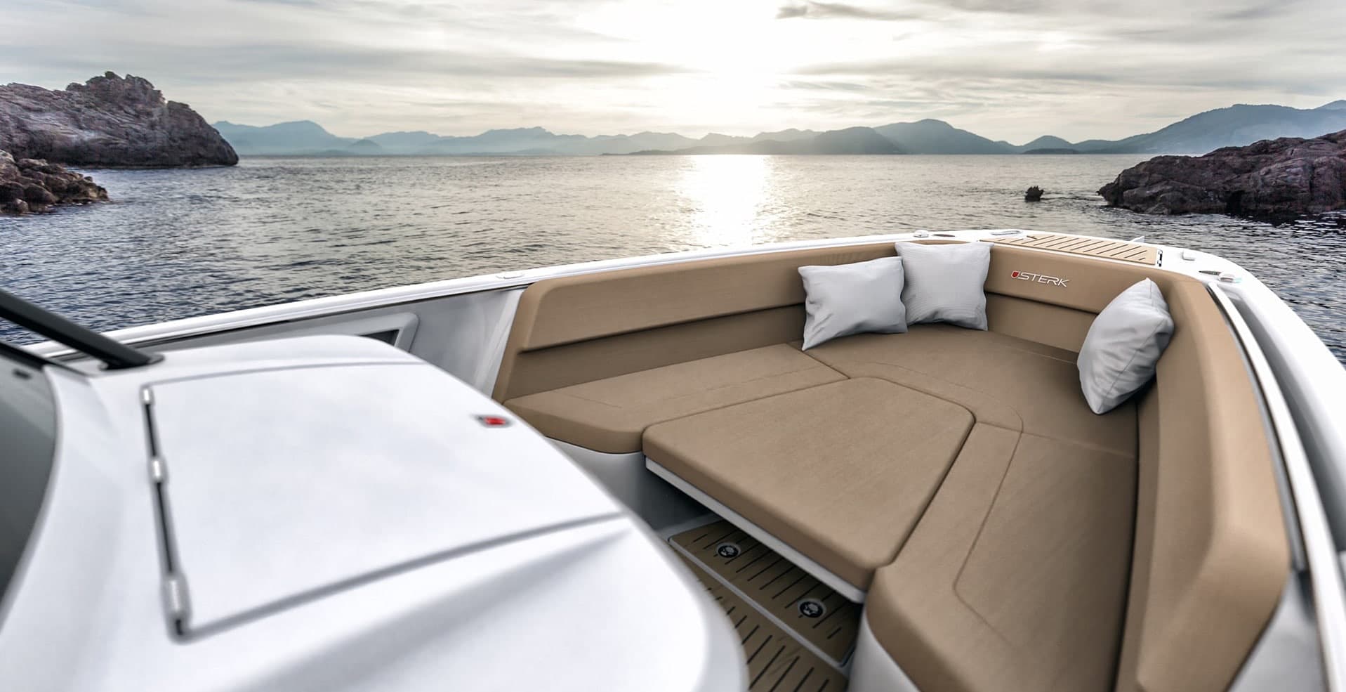 Sterk 31E bow seating area viewed from the helm, with upholstered benches, cushions, and open water beyond