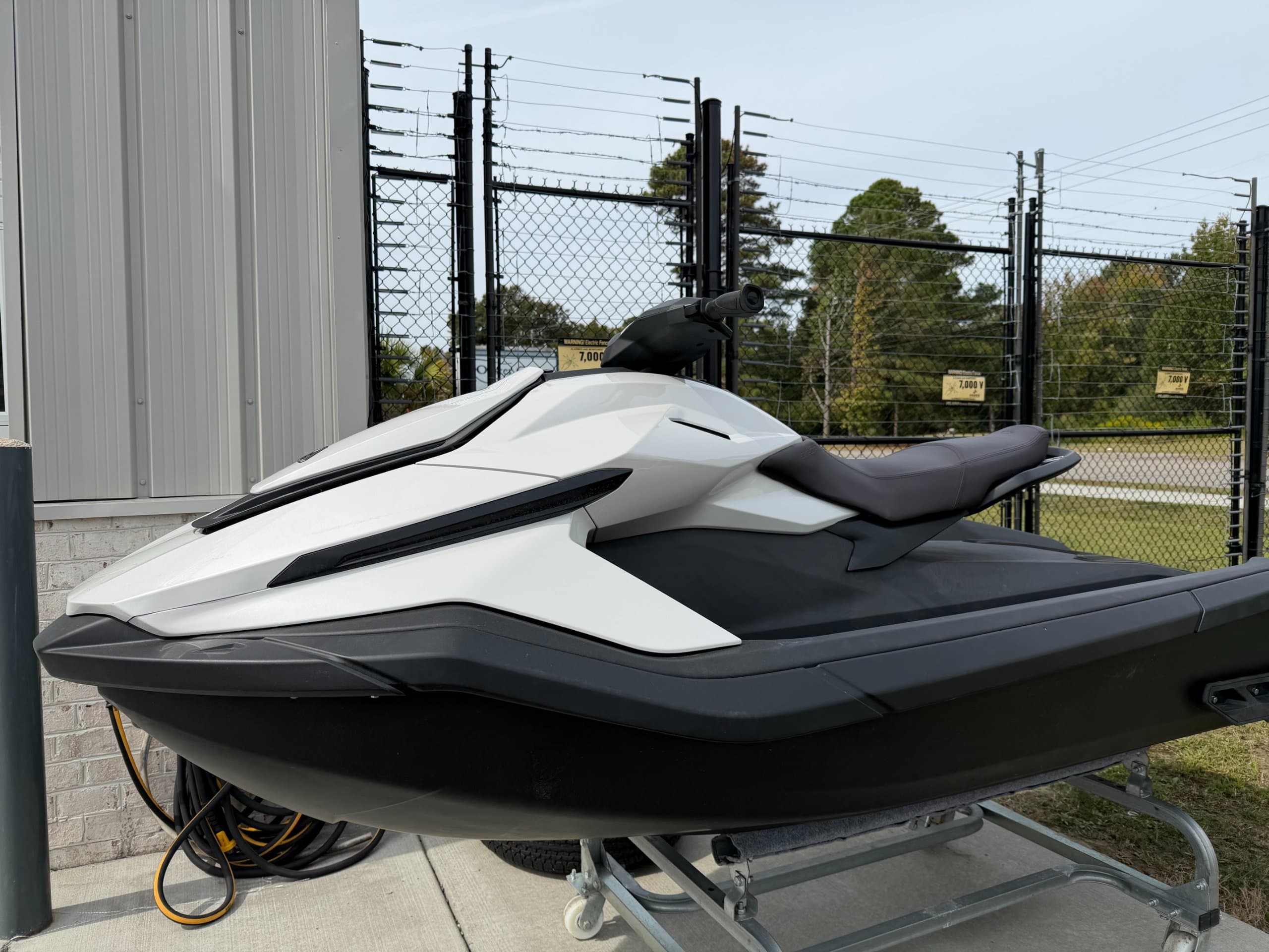 Side view of a white and black personal watercraft on a trailer.