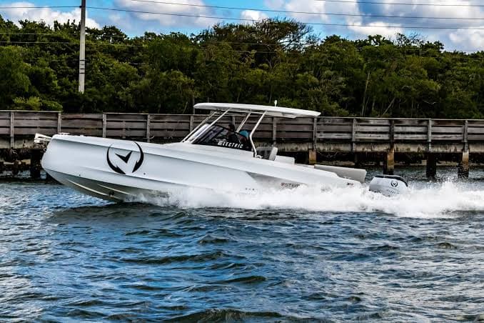 Sterk 31E cruising on the water, viewed from the side with its center console and outboard motor visible.