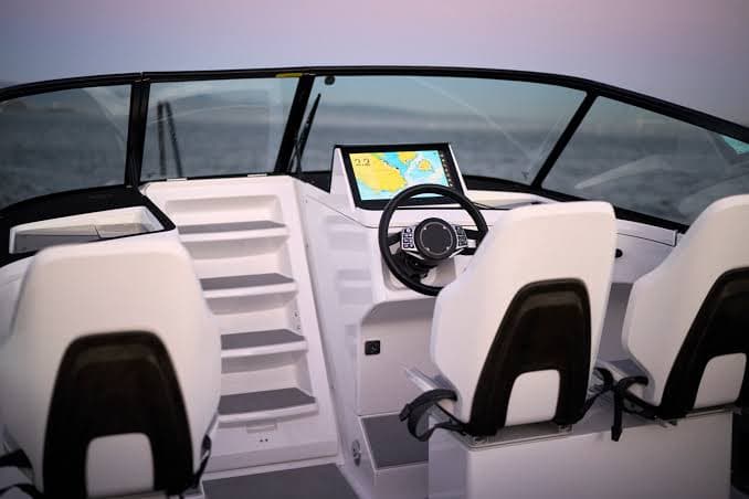 Helm and cockpit of the Candela C-8, viewed from the stern, with forward-facing seats, steering wheel, and display.