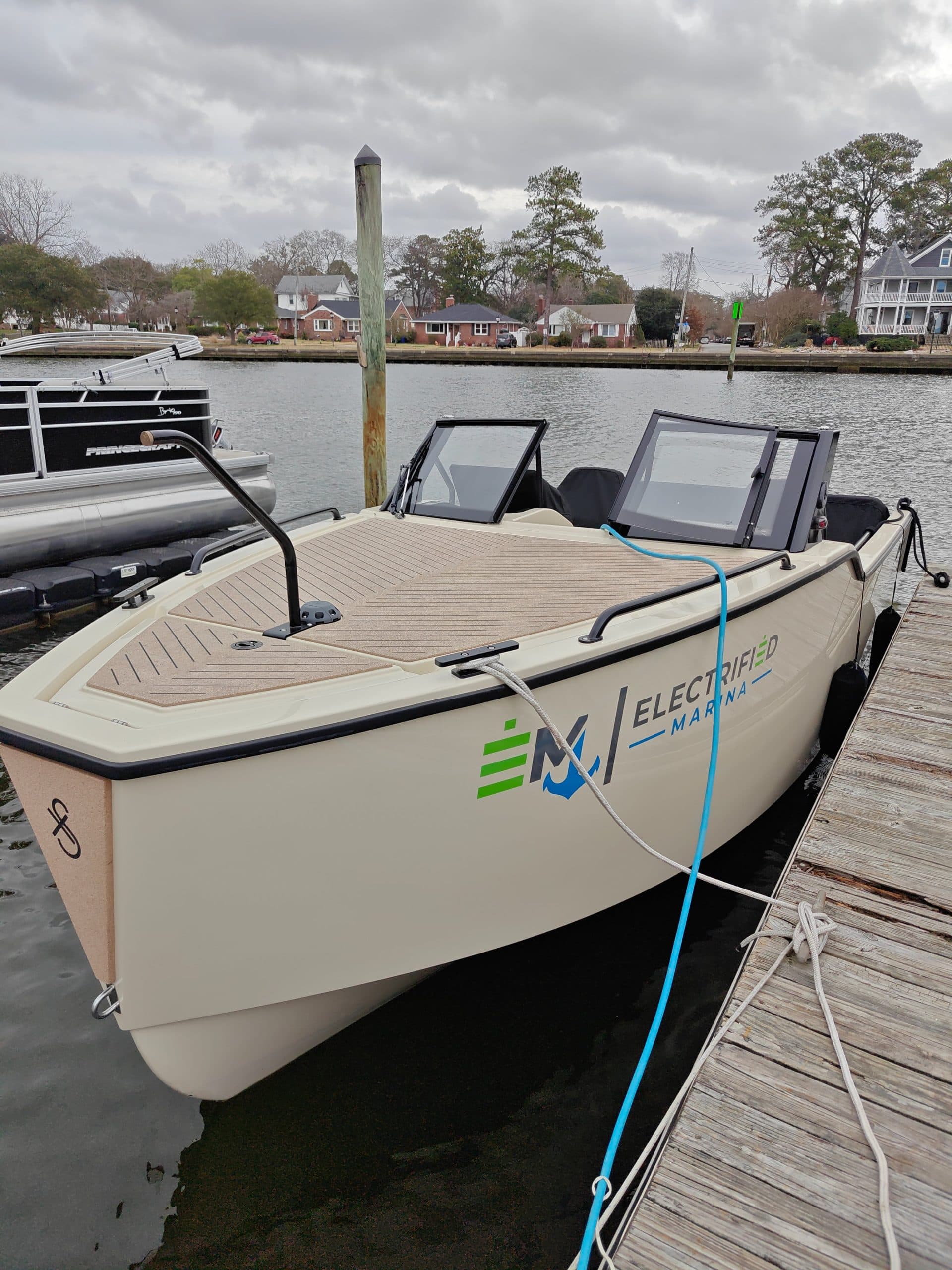 2024 Vision Marine Fantail 217
Electric center-console boat moored at a dock, with twin windshields and waterfront homes in the background.