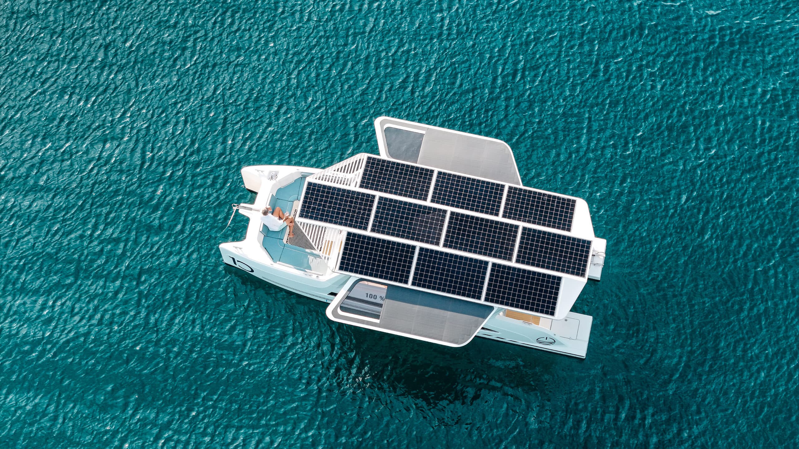 Millikan M10 viewed from above, showing the boat surrounded by turquoise water and covered with rectangular solar panels