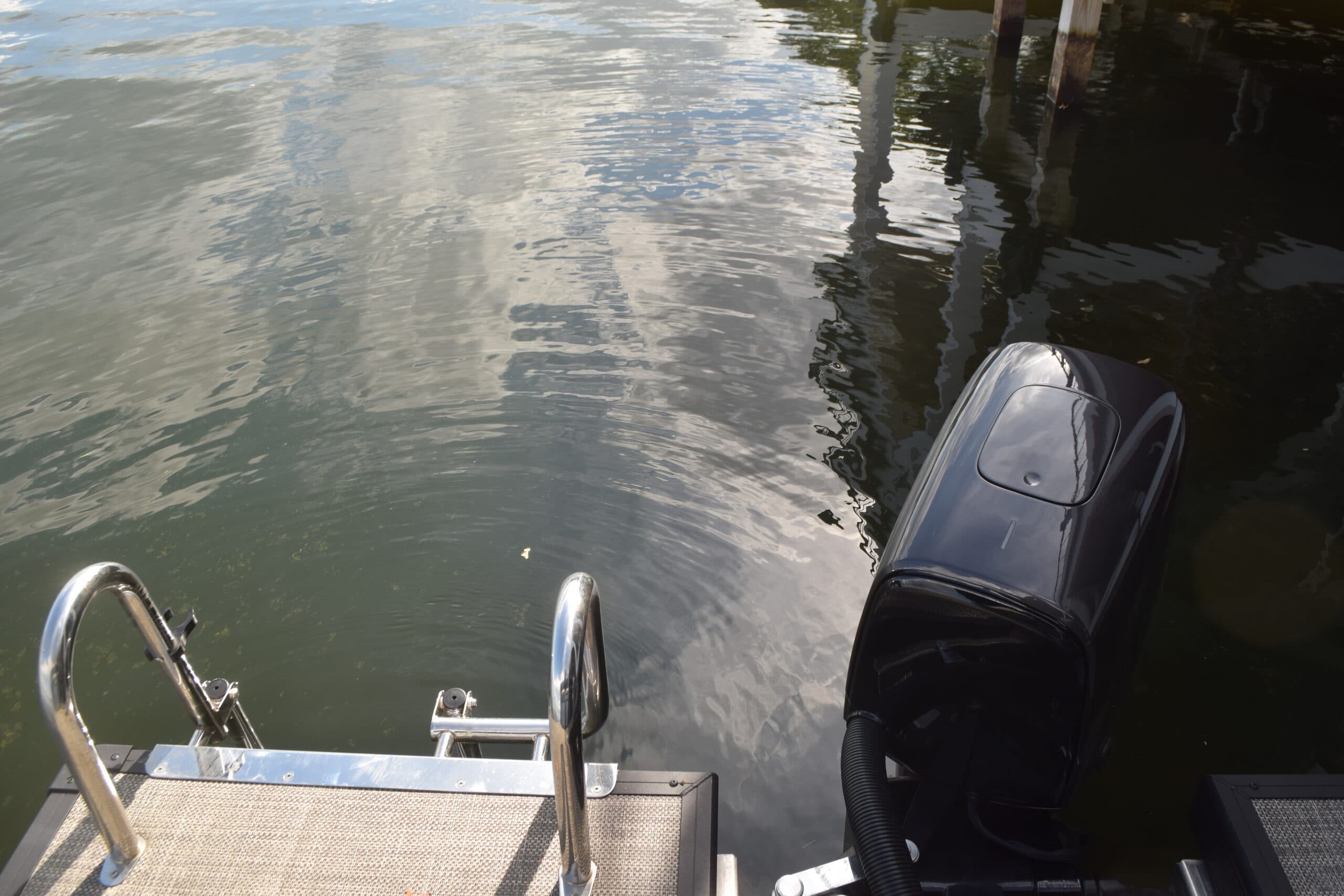 Flagship Discover stern platform and outboard motor viewed from above over the water