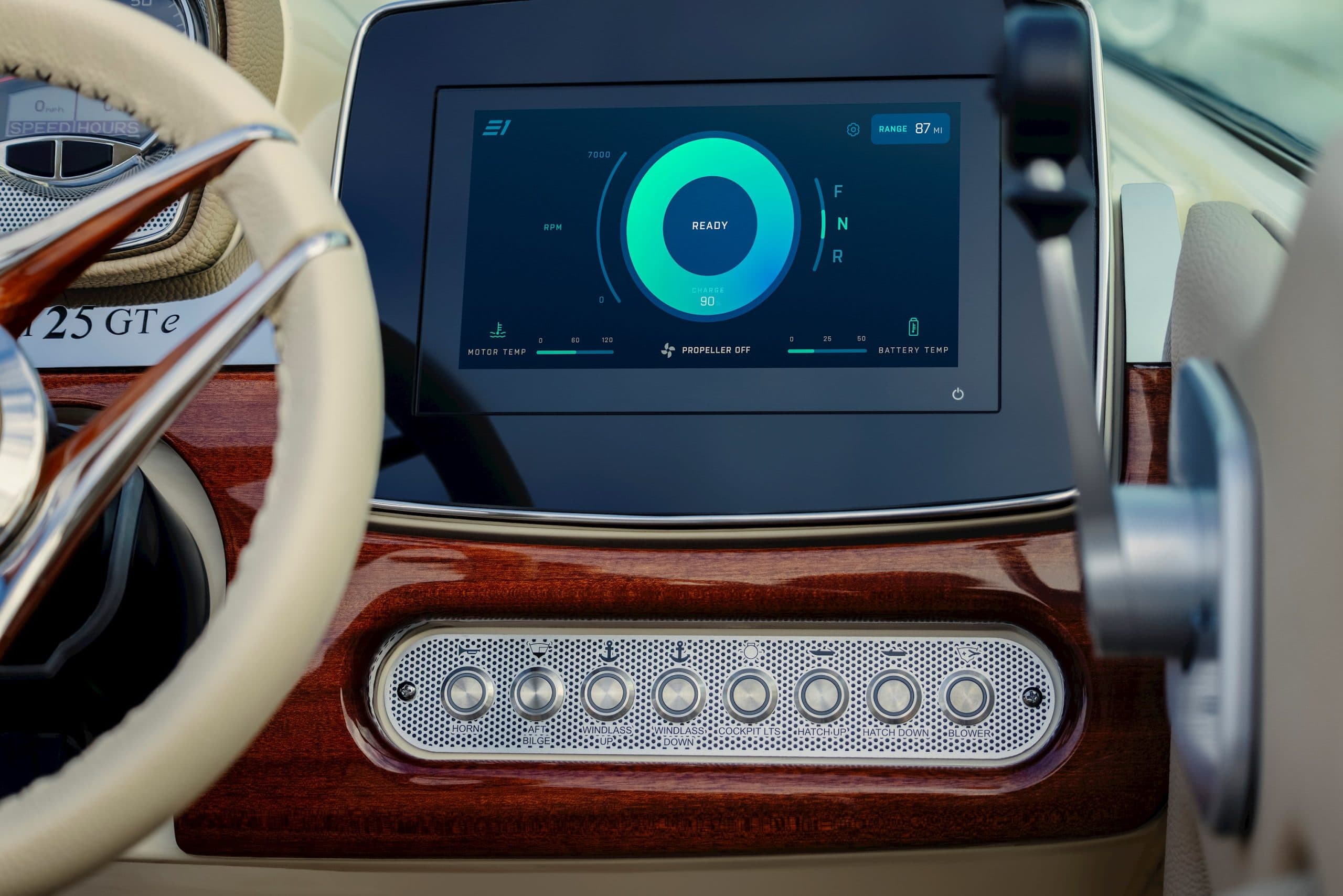 Chris Craft Launch 25 GTe EVOA helm close-up with dashboard touchscreen, steering wheel, and speaker visible.